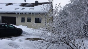 Et hus med garage, parabolantenne og istapper på taget.
