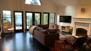 Un salón espacioso con un sofá grande, una chimenea y un televisor.