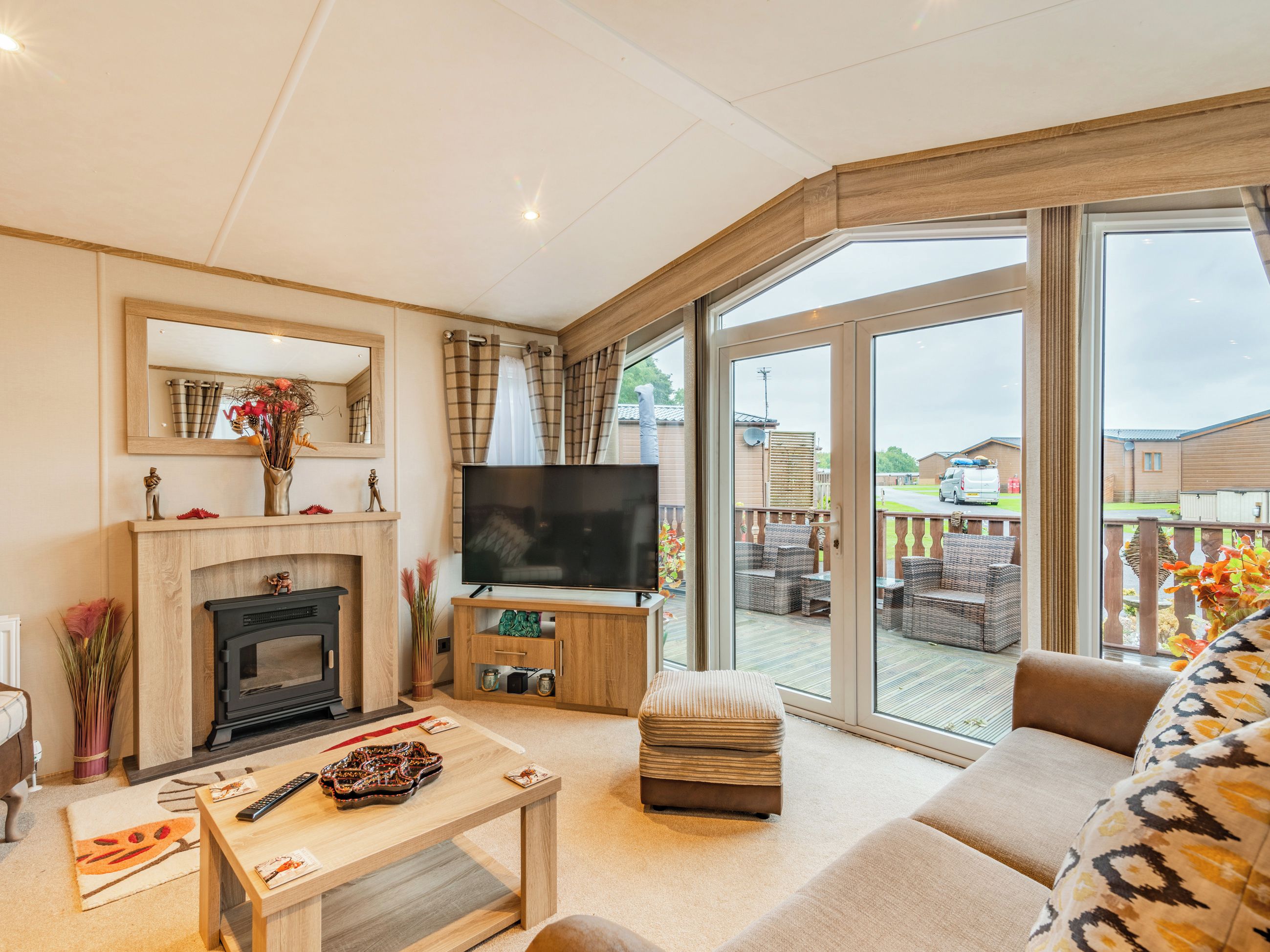 A living room with a fireplace, television, and large sliding glass doors leading to an outdoor patio.