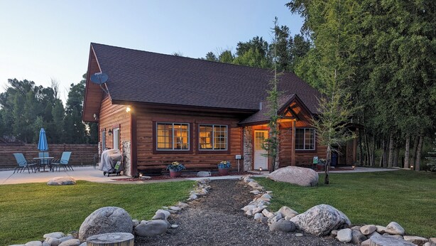 A log cabin with a stone fireplace, outdoor seating, and a well-maintained garden. - House - 3 BR - 2 BA - Sleeps 10
 (Yampa)