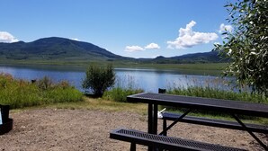 A picnic table by a lake with mountains in the background. - House - 3 BR - 2 BA - Sleeps 10
 (Yampa)