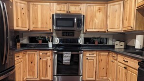 A kitchen with wooden cabinets, a stainless steel microwave, and a built-in oven. - House - 3 BR - 2 BA - Sleeps 10
 (Yampa)