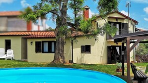 Ein zweistöckiges Haus mit einem Pool im Vordergrund.