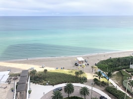 En la playa, arena blanca, sillas reclinables de playa, sombrillas