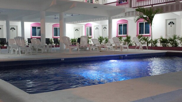 An indoor swimming pool with lounge chairs and a covered area with windows. - Hotel Real Da Vinci Acapulco (Acapulco)