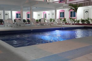 An indoor swimming pool with lounge chairs and a covered area with windows. - Hotel Real Da Vinci Acapulco (Acapulco)