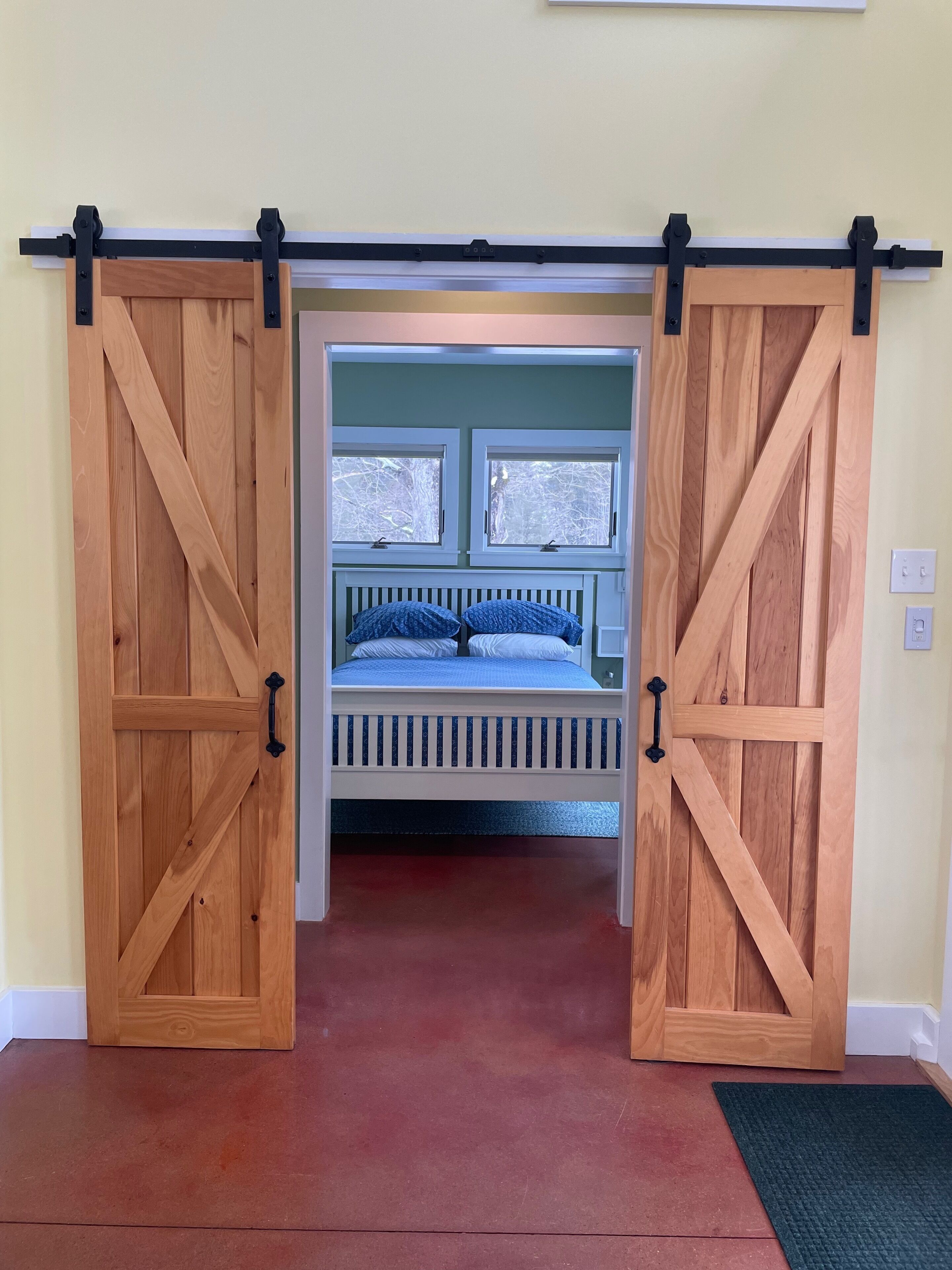 A room with a bed, a window, and a sliding door.