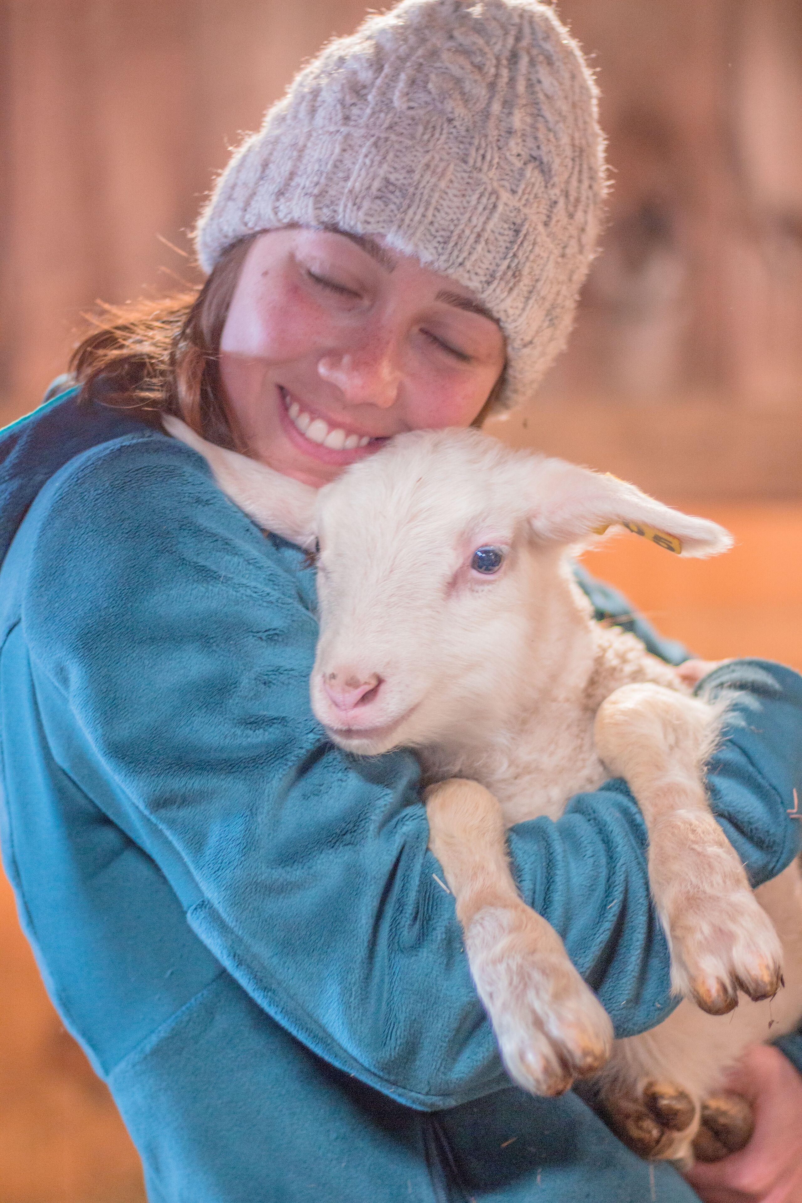 A person holding a lamb.