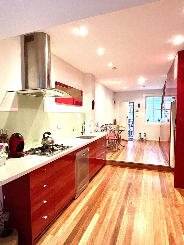 Una cocina moderna con una isla central, electrodomésticos de acero inoxidable y suelo de madera.