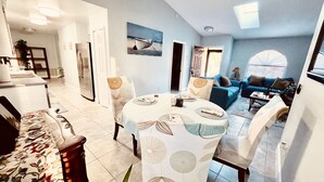Un comedor con una mesa redonda, sillas y vistas al salón.