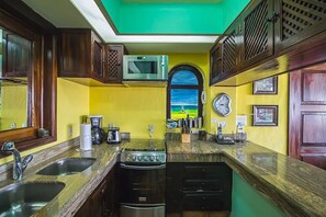 Una cocina con estufa, microondas y fregadero.
