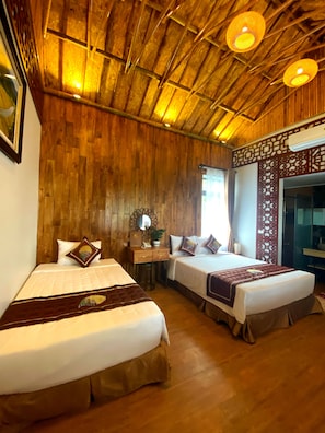 A room with two beds, wooden walls, a ceiling with wooden beams, and a decorative wall panel.
