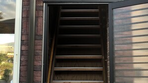 A staircase leading to a door with a sign that reads "West in".