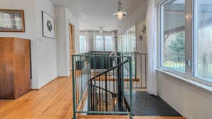 A staircase with a metal railing, a wooden floor, and a ceiling fan. - Dock & Bay Access! Cabin on St. Jerome’s Creek (Ridge)