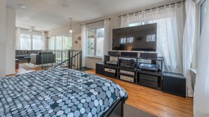 A bedroom with a bed, a TV, a console table, and a staircase. - Dock & Bay Access! Cabin on St. Jerome’s Creek (Ridge)