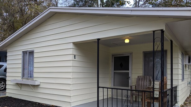 A small, single-story house with a covered porch and a small deck. - Stand alone cabin,  sanitized, full kitchen. (Cadiz)