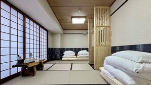 Une pièce traditionnelle japonaise avec un sol recouvert de tatamis, un futon servant de lit, une porte coulissante en bois et un paravent shoji.