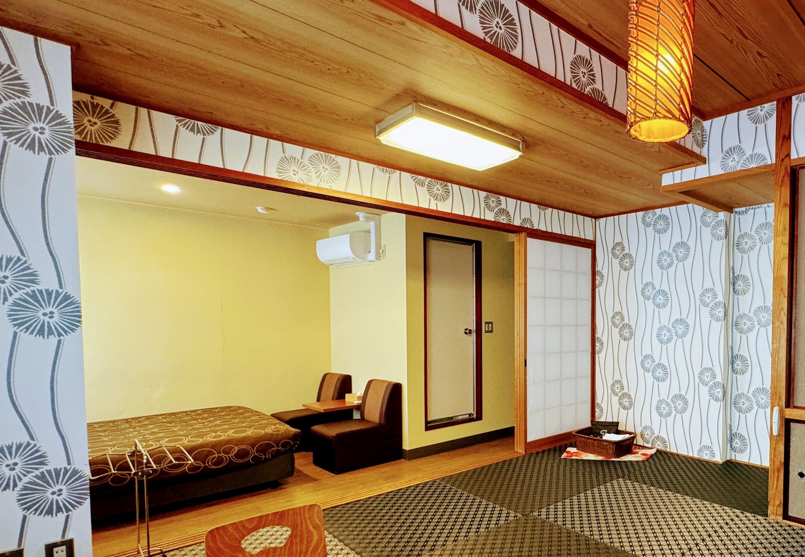 A traditional Japanese-style room with tatami flooring, a low table with cushions, and a sliding door.