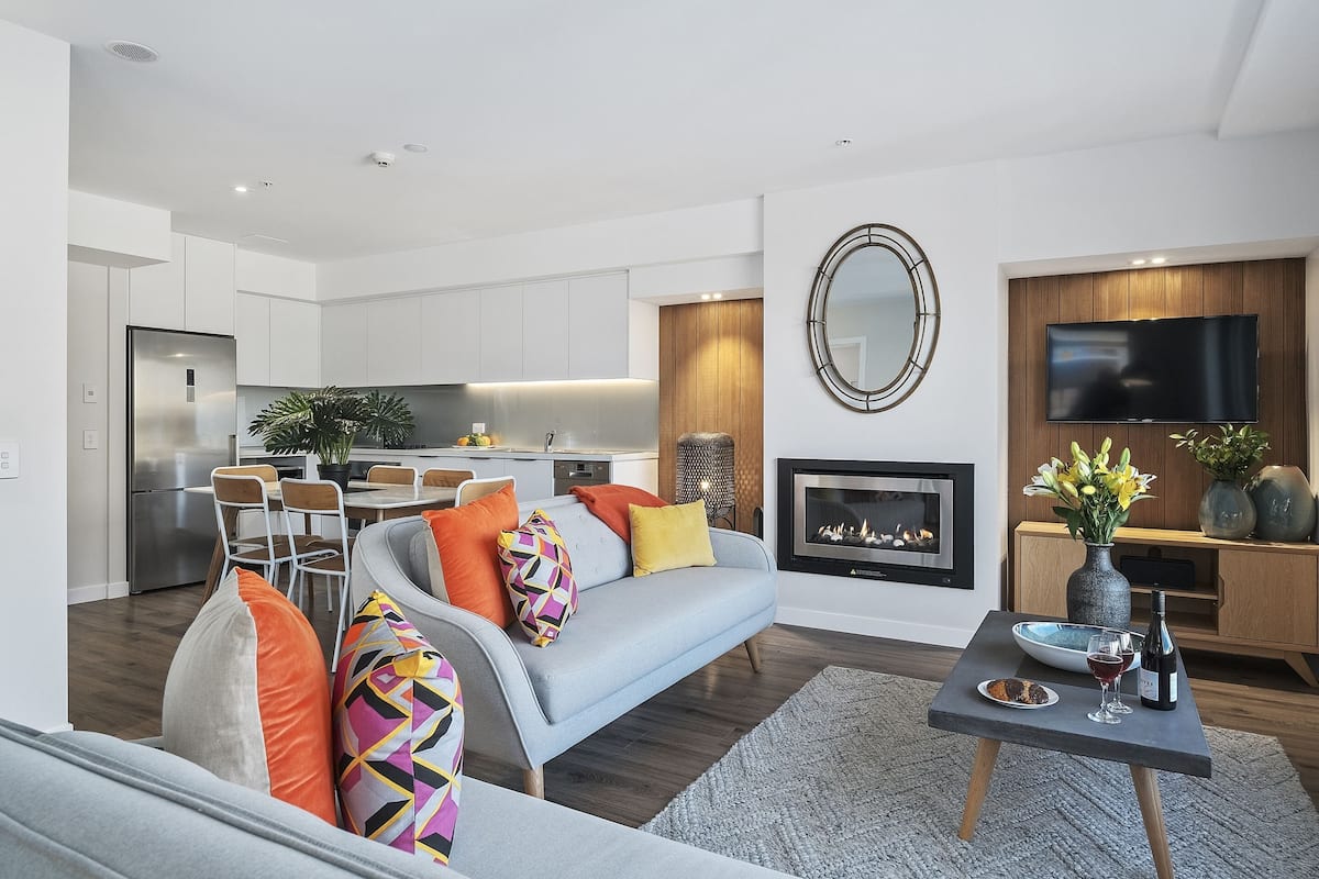 Una sala de estar moderna con sofá, mesa de centro y chimenea.