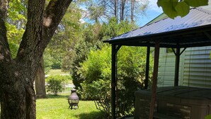 A covered outdoor seating area with a stone pathway leading to it, surrounded by trees and a grassy lawn. - Relax in the Smokeys, Close to Everything (Whittier)