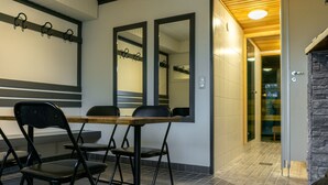 A room with a wooden table, black chairs, and a mirror on the wall. - Motelli Online Oy (Porvoo)