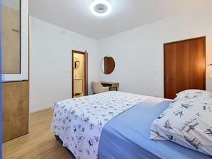 A bedroom with a bed, a wooden wardrobe, a round mirror, and a small table. - Wonderful private villa for 10 people with A/C, WIFI, TV, balcony and pets allowed (Zadar)