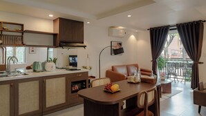 Una cocina moderna con comedor, sofá y balcón con cortinas.