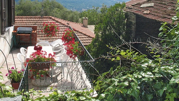 A balcony with outdoor furniture, potted plants, and a view of mountains. - Beautiful private villa for 5 people with pool, TV, terrace and pets allowed (Dolcedo)