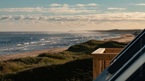 A coastal view with a wooden structure, possibly a beach house or cabin, overlooking the ocean.