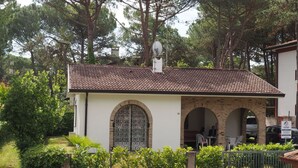 Un bâtiment doté d’un toit recouvert de tuiles, de fenêtres en arc de cercle et d’une antenne parabolique.