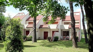A building with a symmetrical facade, multiple balconies, and a well-maintained lawn. - Wonderful  villa for 8 people with A/C, TV, terrace and pets allowed (San Michele Al Tagliamento)