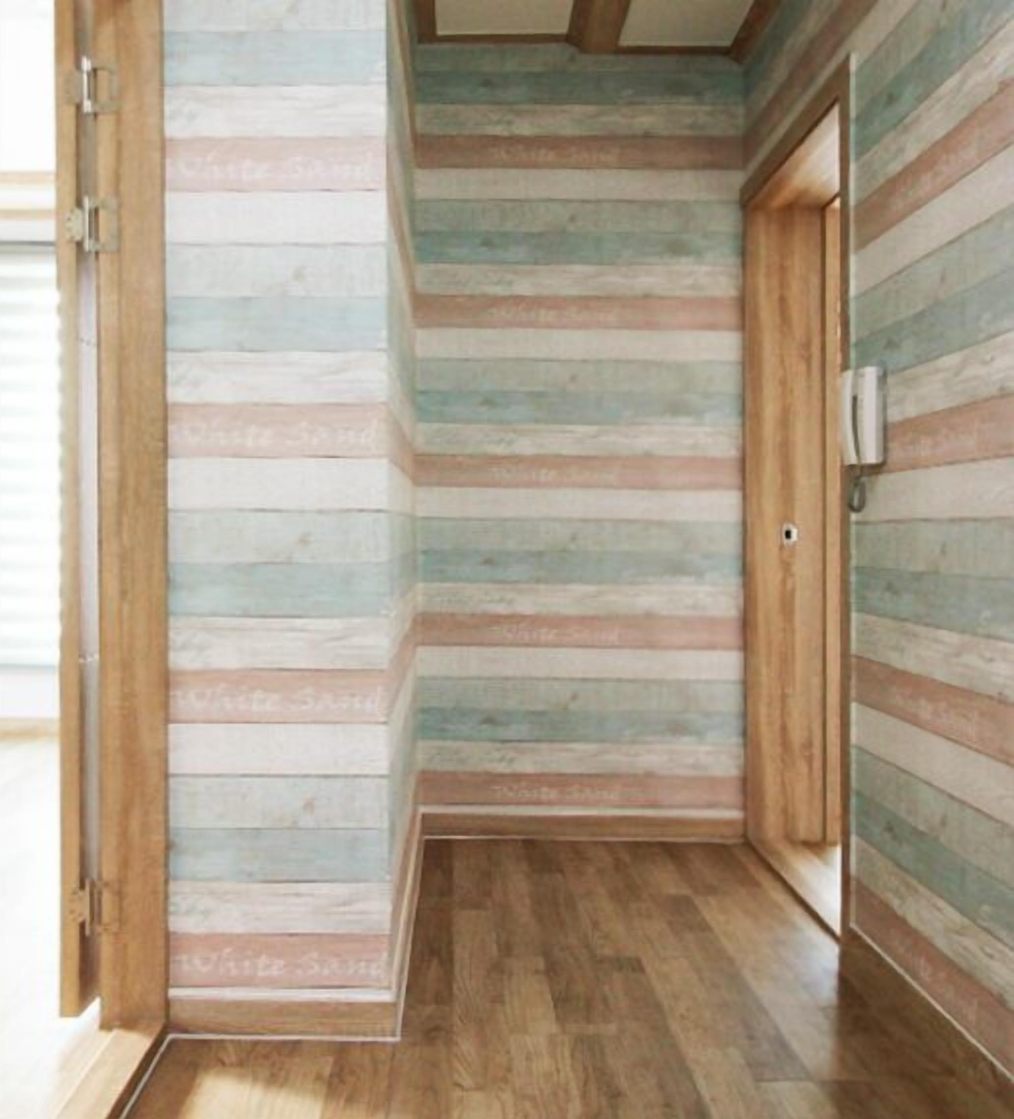 A narrow hallway with wooden paneling and a wooden floor.