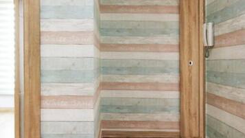 A narrow hallway with wooden paneling and a wooden floor.