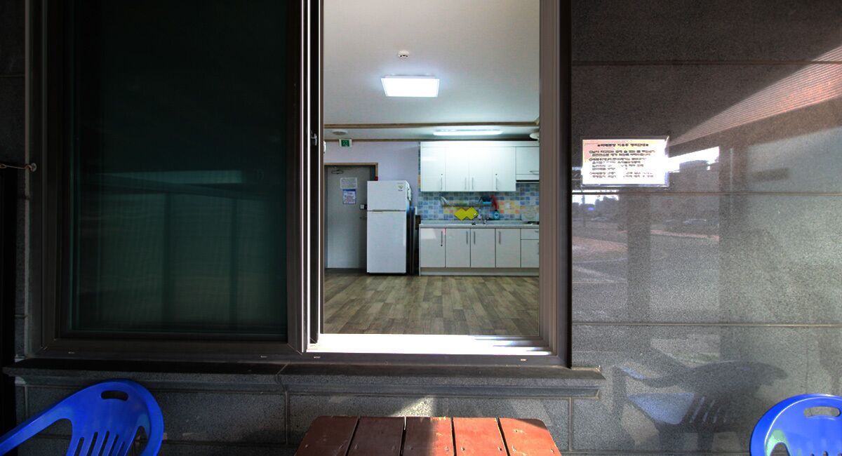 A view of a kitchen with white cabinets, a refrigerator, and a tiled backsplash.