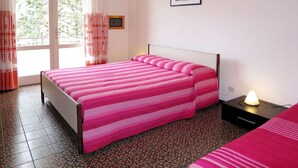 A bedroom with a bed, a nightstand, a lamp, a window with curtains, and a framed picture on the wall. - Nice apartment for 5 guests with A/C, TV, balcony and pets allowed (Ca Grande Pineda)
