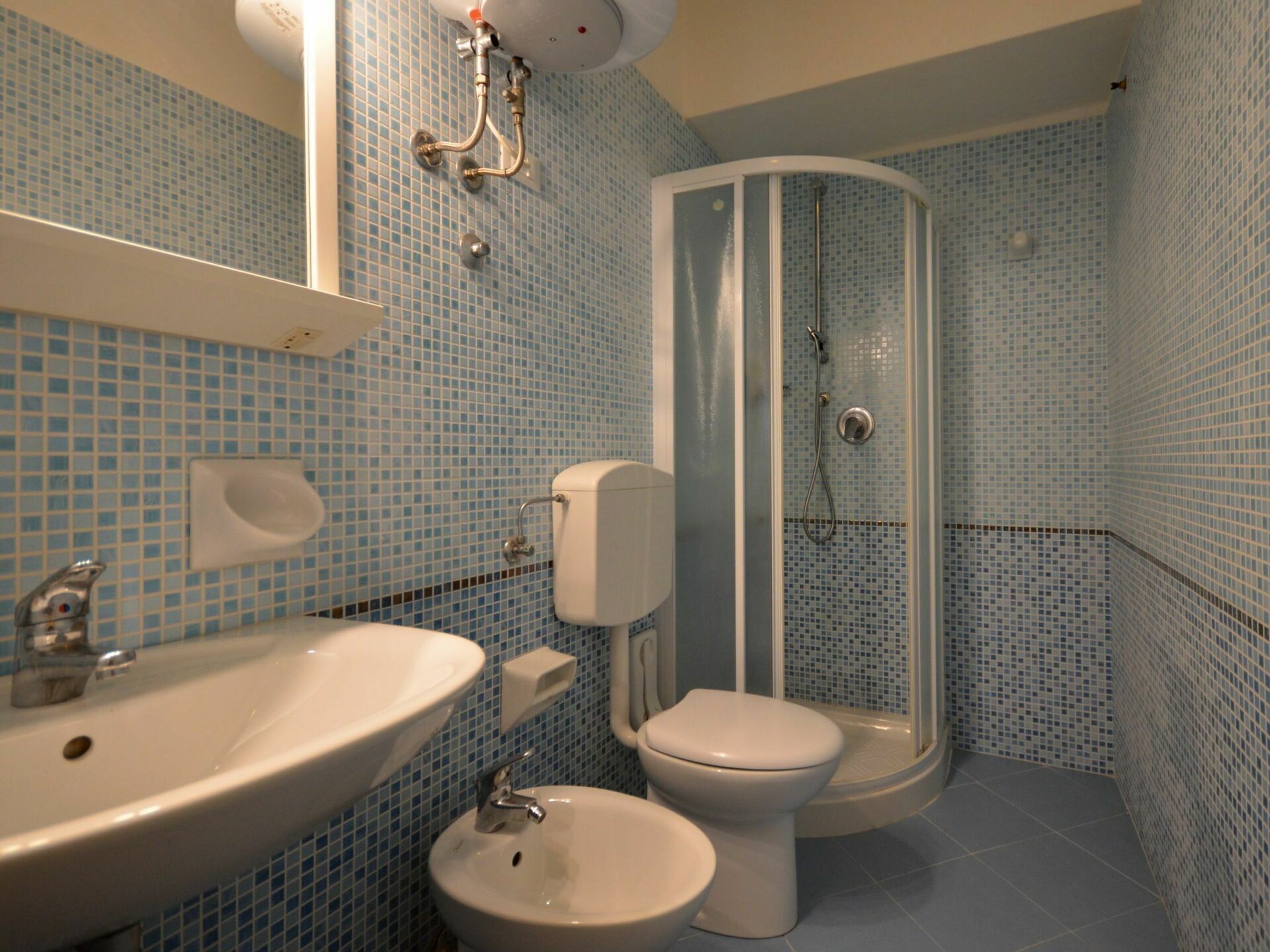 Ein Badezimmer mit Waschbecken, Bidet, Toilette und Duschkabine.