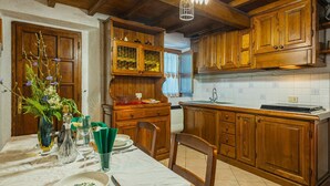 A wooden kitchen with a dining table set for two, featuring a vase with flowers and glassware. - Stunning private villa for 4 guests (Pontestazzemese)