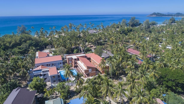 An aerial view of a resort with multiple buildings, palm trees, and a beach. - Traveller Lodge Ngapali by River Top - Hostel (Ngapali)
