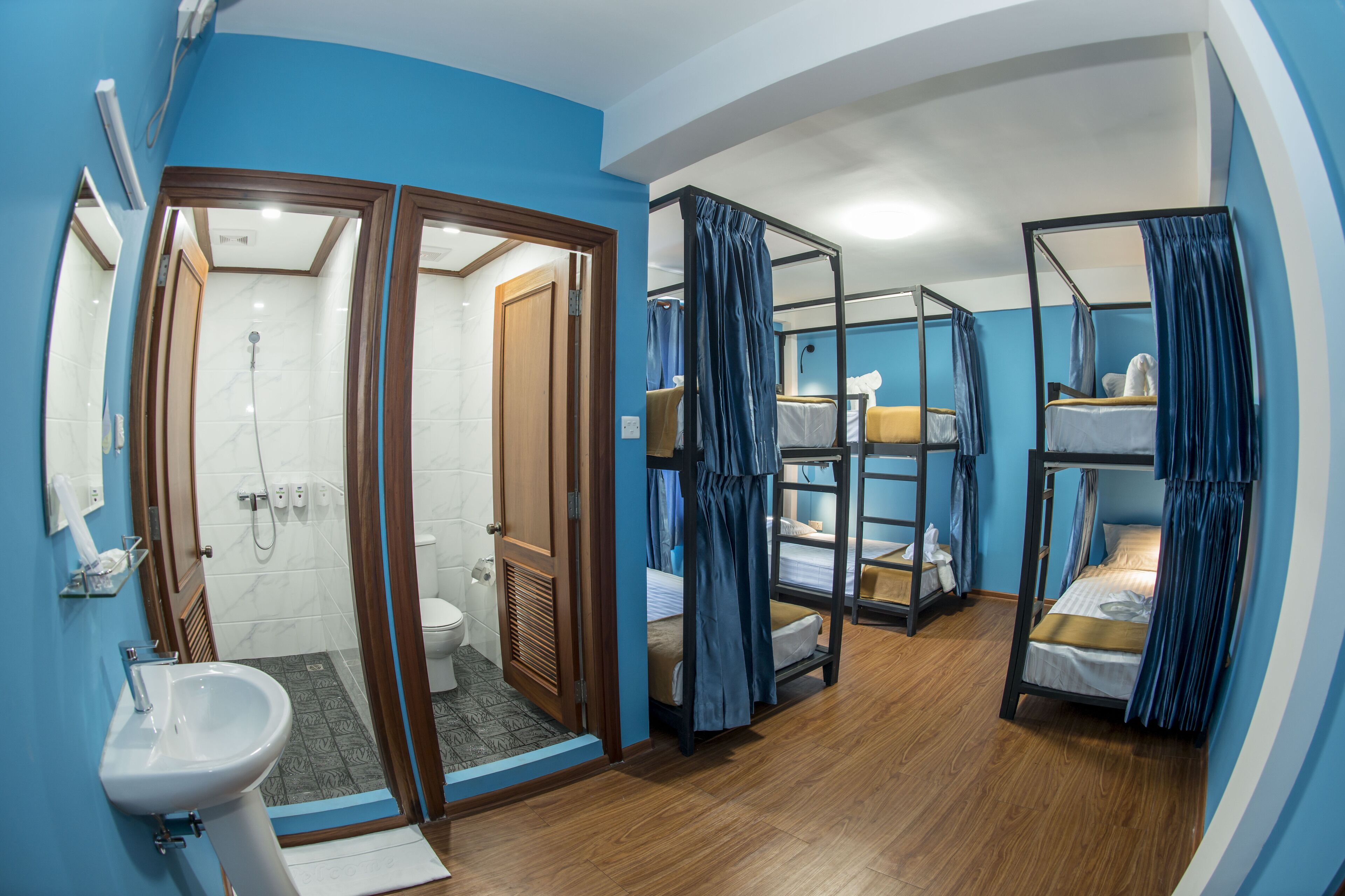 A compact room with a shower, toilet, and bunk beds.