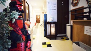 A hotel hallway with a calendar, a notice board, and a plant. - Start One Home Senzoku A (Tokyo)