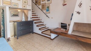 Un escalier menant à un niveau supérieur, les murs étant ornés de tableaux encadrés.