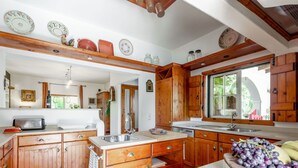 A spacious kitchen with wooden cabinets, a large island, and a window providing natural light.
