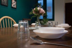 A dining table with a white bowl, a clear glass, and a spoon. - Aurora Court (George Town)