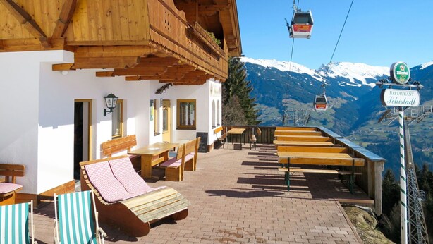 A wooden building with a balcony overlooking a mountain view.