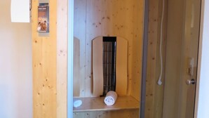 Ett träskåp med en glasdörr, inuti finns ett vitt föremål och ett svart föremål på hyllan.
