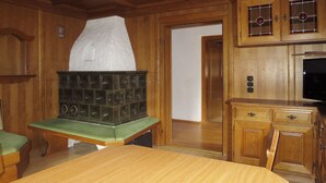 Un intérieur en bois avec un banc rembourré de couleur verte, une table en bois et un système de haut-parleurs.