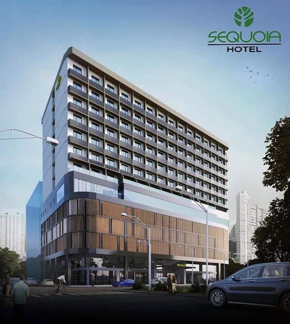 Un moderno edificio de hotel con varios pisos, ventanas grandes y una entrada destacada.