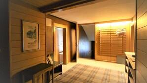 A room with wooden walls, a plaid carpet, a framed picture, a bench, and a door leading to another room. - Cosy apartment for 6 people with WIFI, TV and balcony (Mayrhofen)