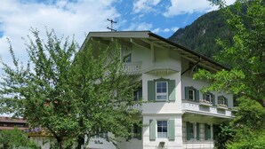 A two-story building with a balcony, a sign reading "Villa Planter," and a mountain backdrop. - Cosy apartment for 6 people with WIFI, TV and balcony (Mayrhofen)
