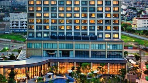 Ein hoch aufragendes Hotel mit modernem Design, das ein auffälliges Logo oben trägt.